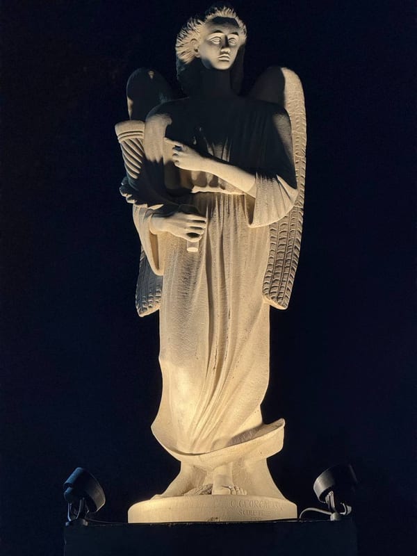 A white angel statue lit at night