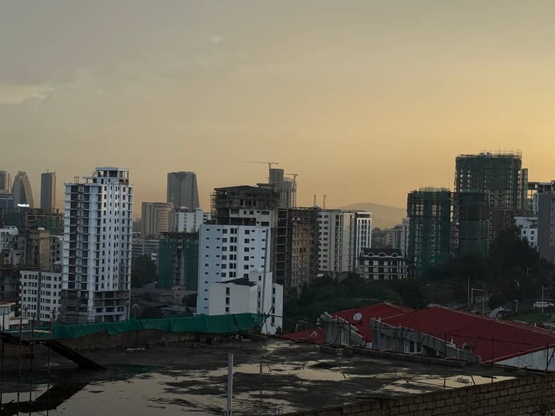 Towers and cranes over the rooftops at dusk