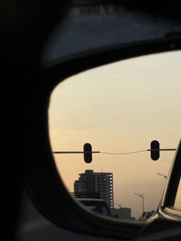 Sunset and traffic lights in a car's side mirror