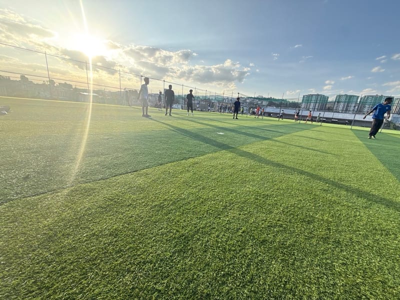 Football on a pitch as the sun goes down