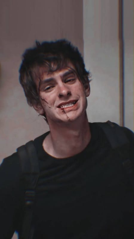 Andrew Garfield grinning, a cut on his cheek