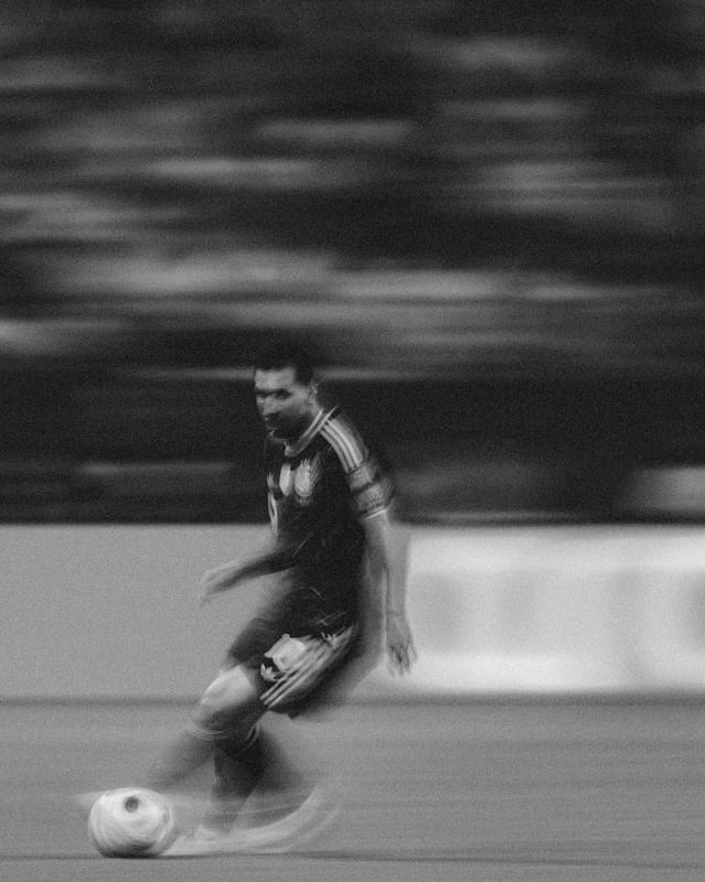 Messi dribbling, the stadium a blur behind him
