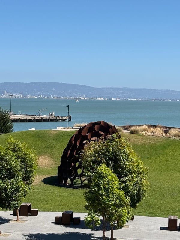 A park above the bay, a rusted dome sculpture on the lawn