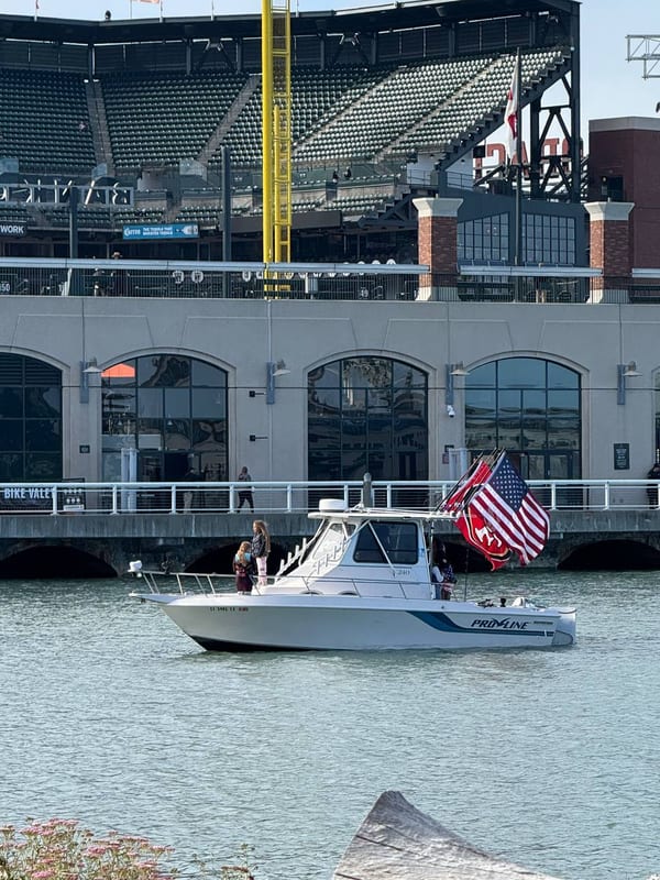 A boat flying a flag below Oracle Park