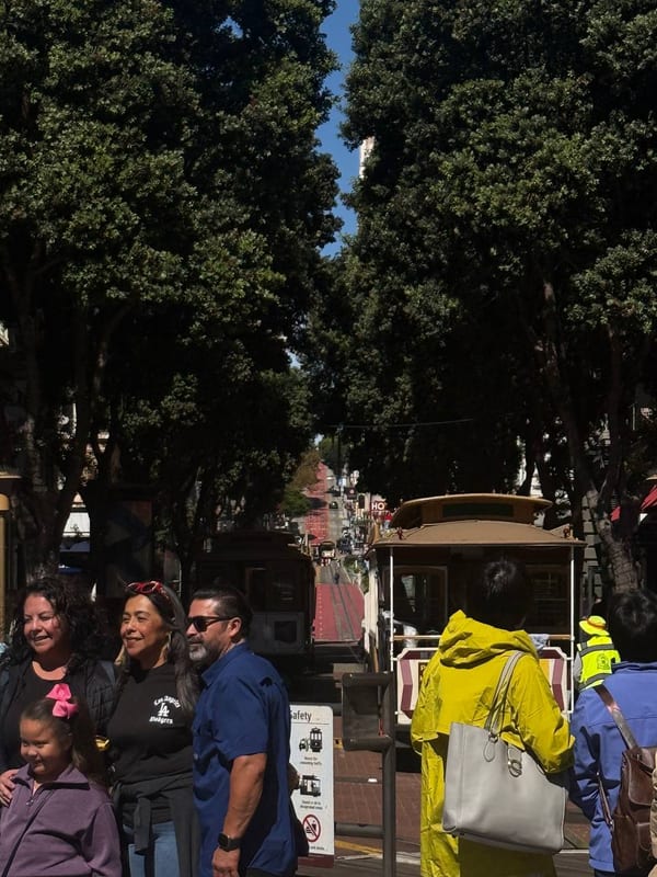 A family posing in front of a cable car