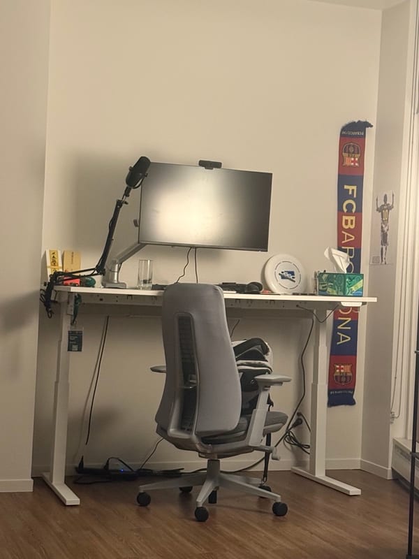 A standing desk by the window, an FC Barcelona scarf on the wall