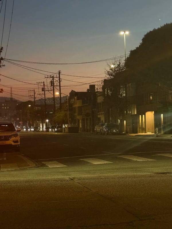 An empty street at dusk under power lines