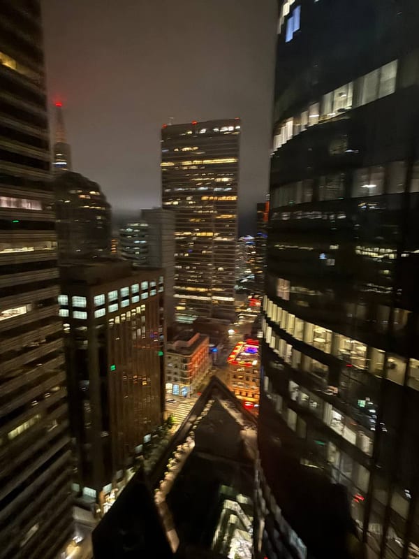 Lit office towers at night, looking down