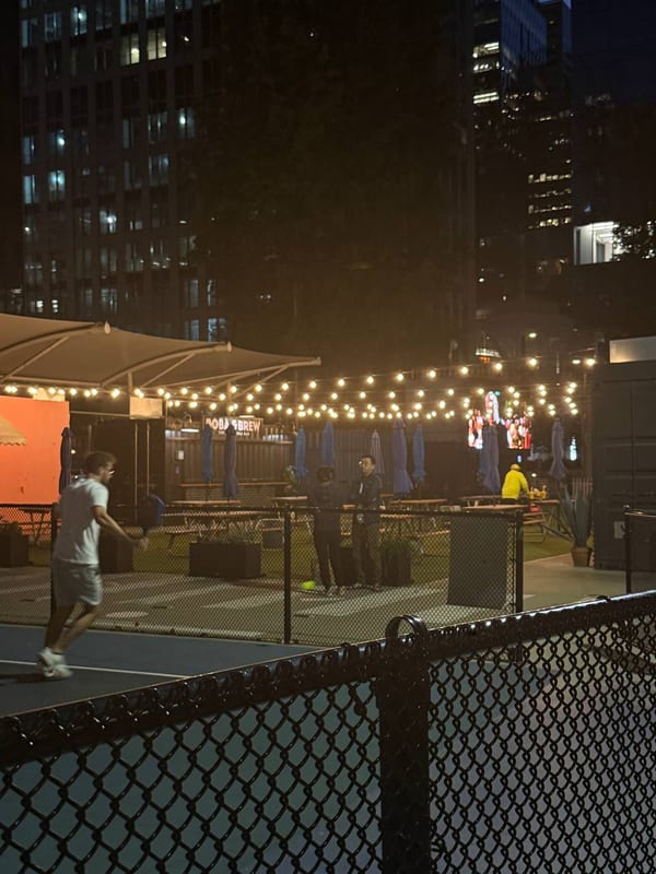 A lit court under string lights at night