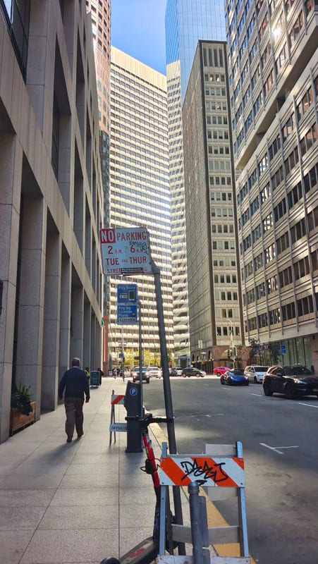 A sidewalk between tall buildings