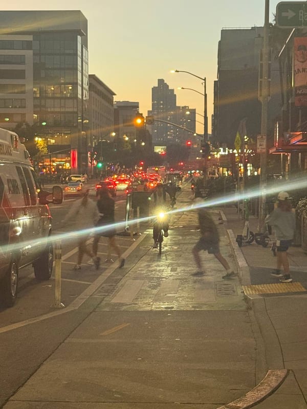 A street at sunset, a flare across the frame