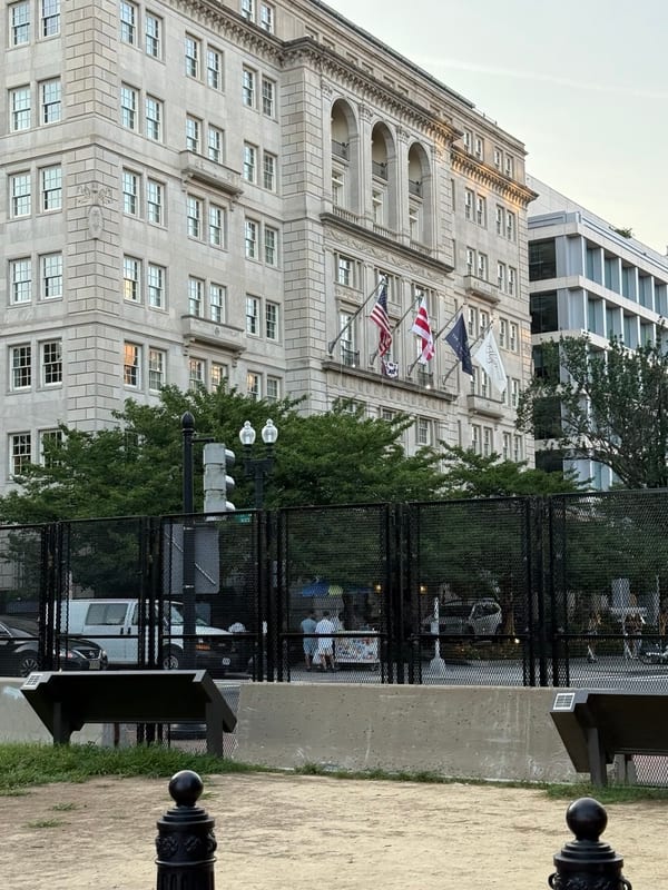 An old hotel across the square, flags out front
